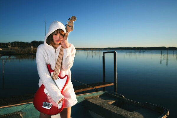 A girl with a guitar on a boat