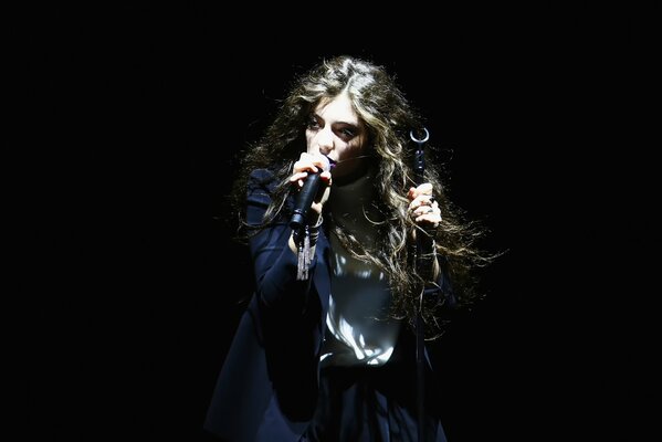 New Zealand singer with a microphone in her hand