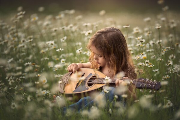 A girl is sitting on a chamomile field