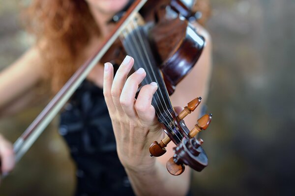 A girl in a dress playing the violin