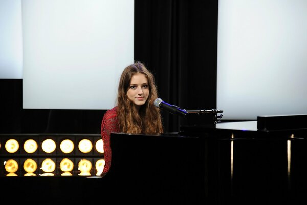 The British singer is sitting at the piano