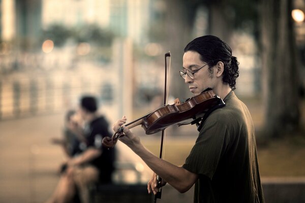 A musician plays the violin on the street