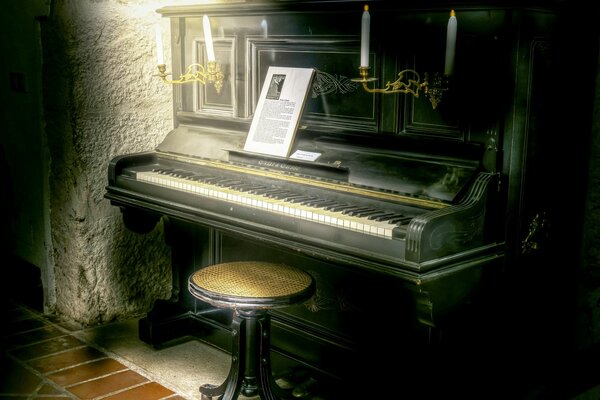 Old black piano with sheet music