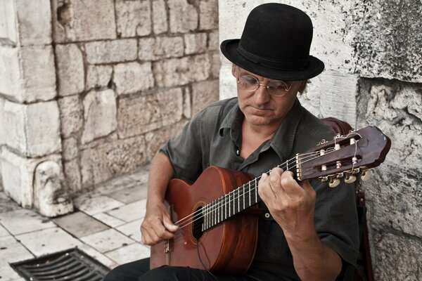 Chapeau lunettes homme guitare sur les escaliers