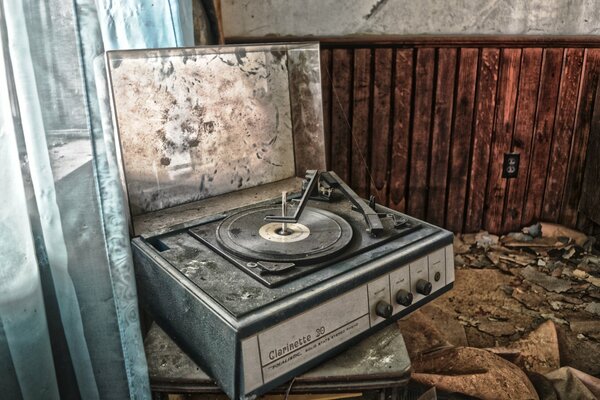 An old record player in an abandoned dirty apartment