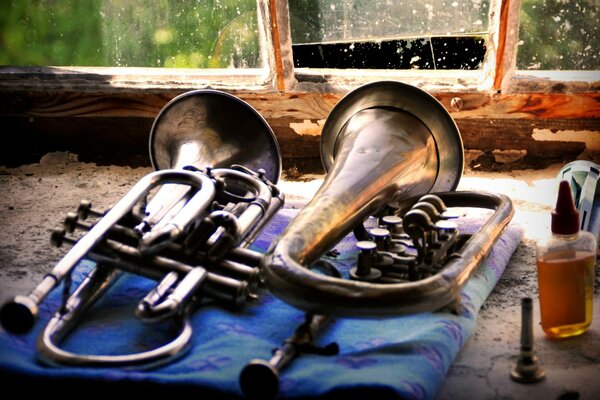 Musikinstrumente liegen auf einem Stück Stoff auf einer alten Fensterbank