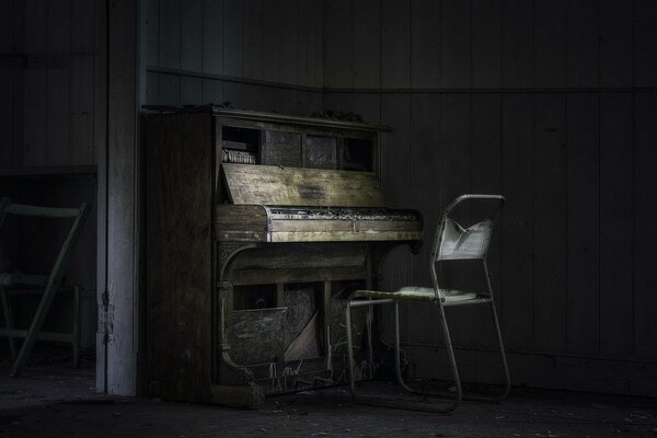 An old piano and a chair in an abandoned house