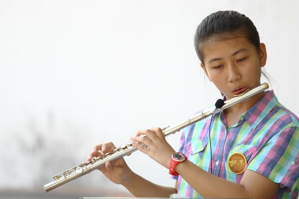 Asiatische Mädchen spielt Flöte