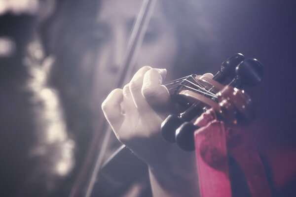 Chica tocando el violín en un fondo borroso