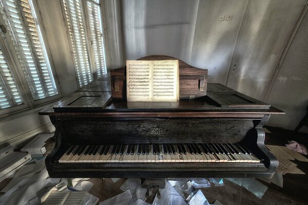 An old piano and sheets of sheet music around