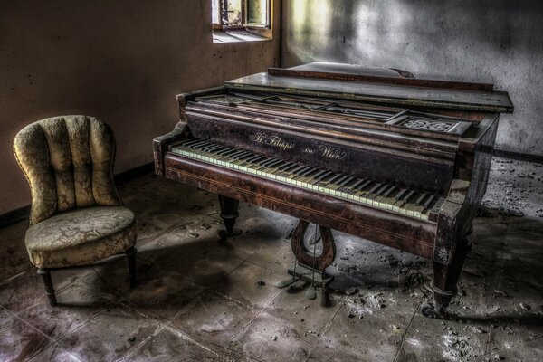 Ein Sessel und ein altes Klavier in einem verlassenen Haus