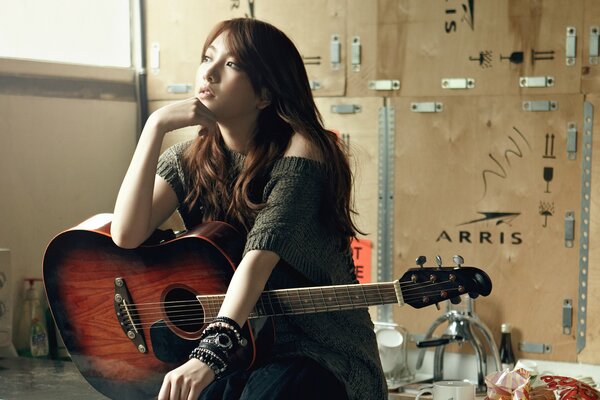 Ragazza asiatica con chitarra. cantante