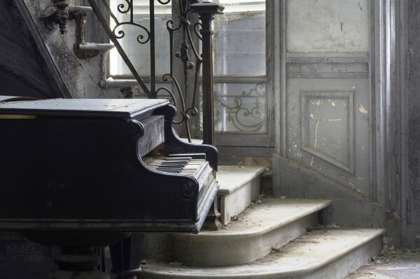 Piano near the stairs in an abandoned room