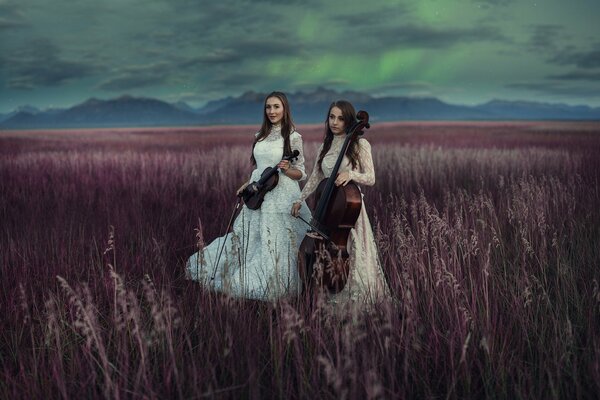 Dos chicas en el campo tocando el violín