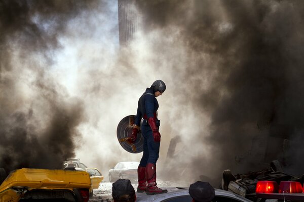 Captain America stands with a shield against the background of smoke