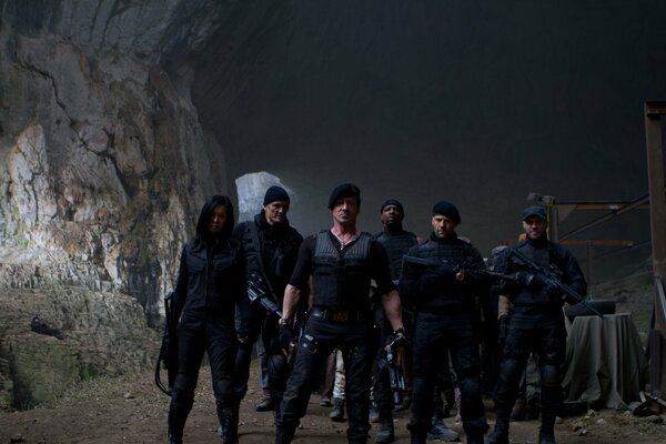 Actors from the movie The Expendables 2 on the background of a rock