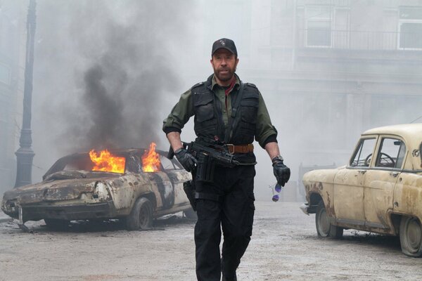 Chuck Norris on the background of a burning car