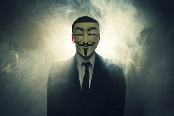 A man in smoke, dressed in a tight suit and an anonymous mask from the movie v means vendetta