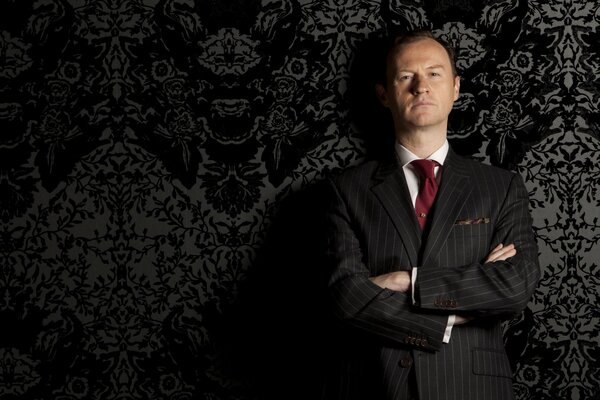 Mark Gatiss in a suit with a red tie