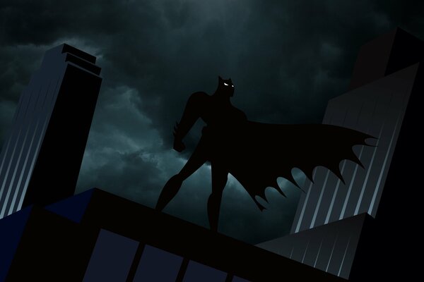 Batman w rozwijającej się pelerynie na dachu w nocy