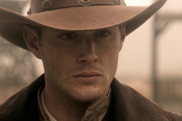 Dean Winchester steht im Bild eines Cowboys mit einem Hut auf dem Kopf