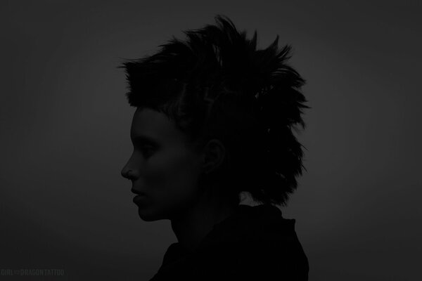 Silhouette of an actress from the movie The Girl with the Dragon Tattoo on a dark background. 