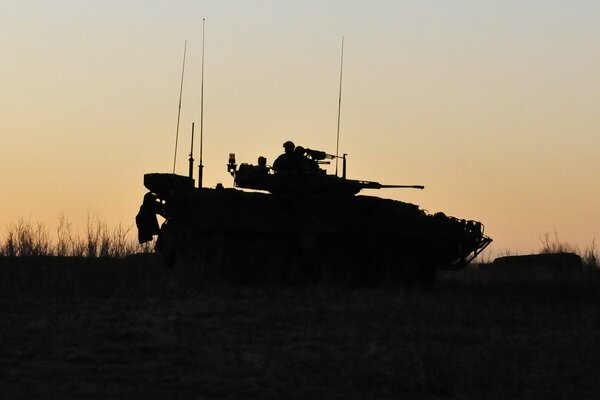 Silhouette eines Panzers und eines Soldaten bei Sonnenuntergang