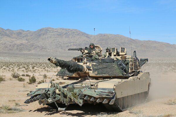 A military tank rides on the ground