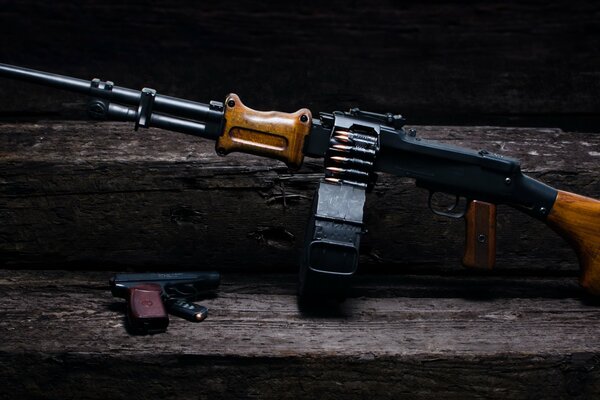 A light machine gun and a pistol on a wooden stand