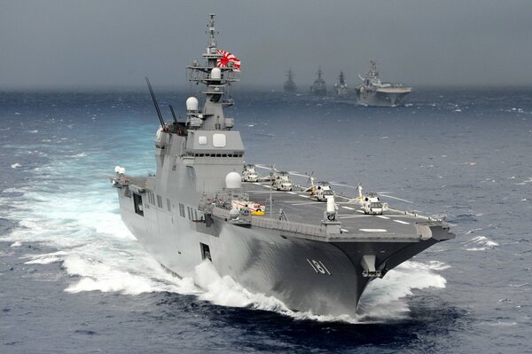 The helicopter carrier sails in the blue sea