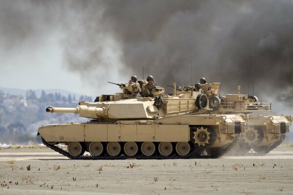 Soldiers with weapons ride on a tank