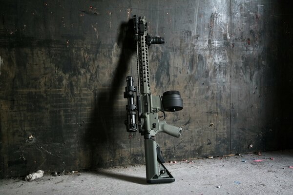 An assault rifle stands against the wall