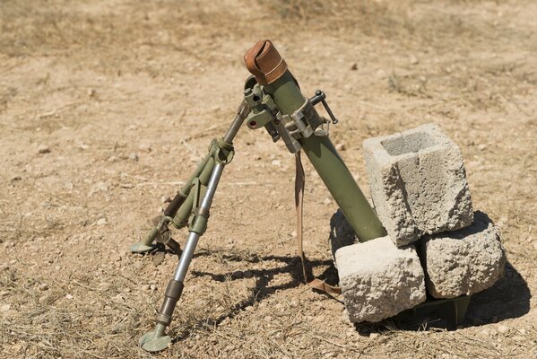 Mortero montado arma en el campo con piedras