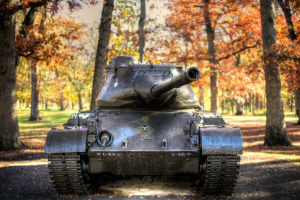 Tank auf dem Hintergrund des Herbstwaldes