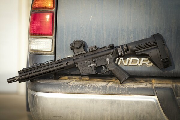 Rifle on the bumper of the car