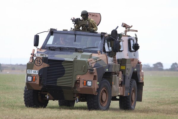 Soldaten fahren mit einem gepanzerten Truppentransporter über das Feld