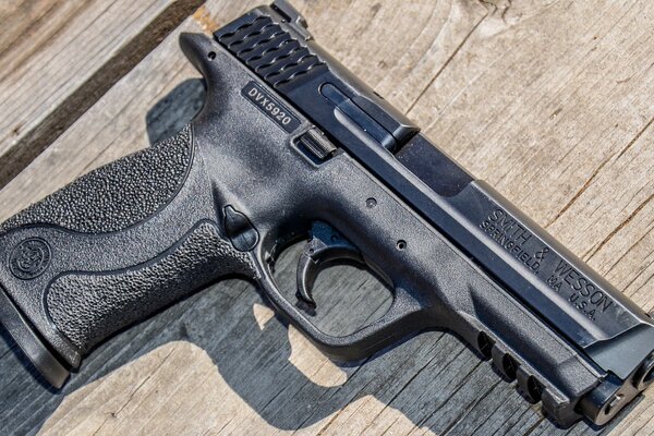 The gun is on the table. Wooden background