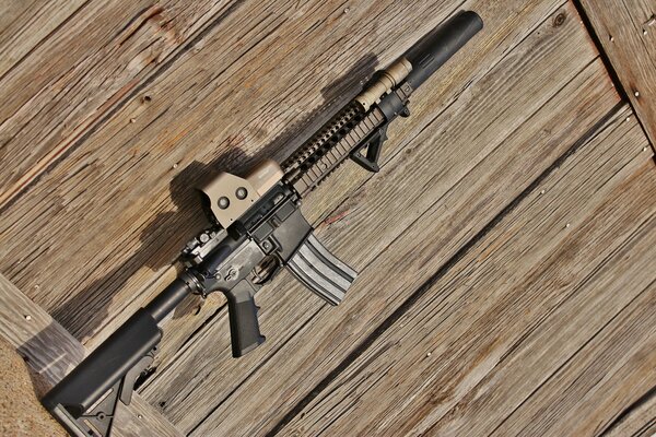 Assault rifle on a wooden floor background