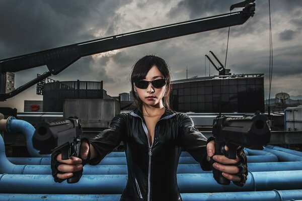 A girl in a black jumpsuit and glasses shoots with two hands