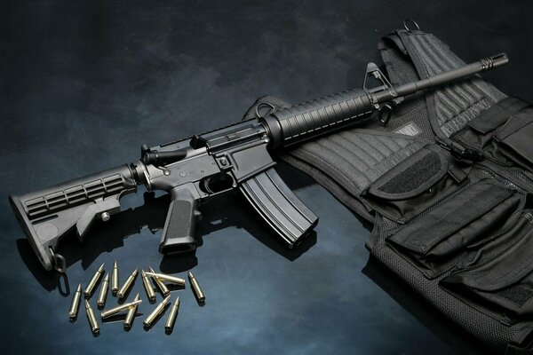 On a black background there is a machine gun cartridges and a bulletproof vest