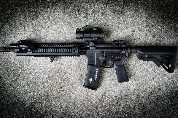 Black assault rifle on a gray background