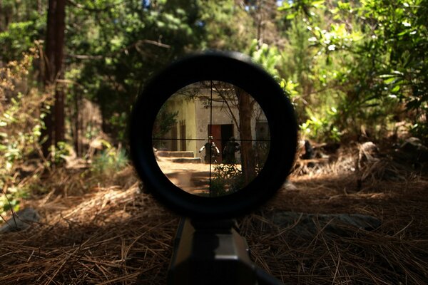 A soldier takes aim for a shot in the middle of the forest