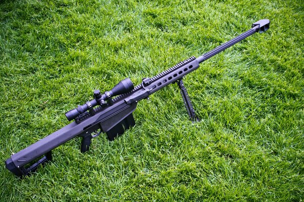 Крупнокалиберная снайперская винтовка на зеленой траве
