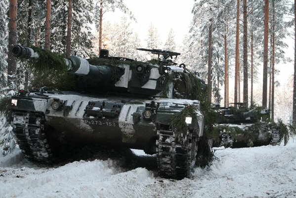 Carro armato leopardo cavalca attraverso la foresta invernale