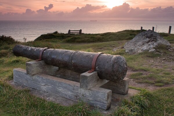 Alte Kanone auf Holzstäben am Meer