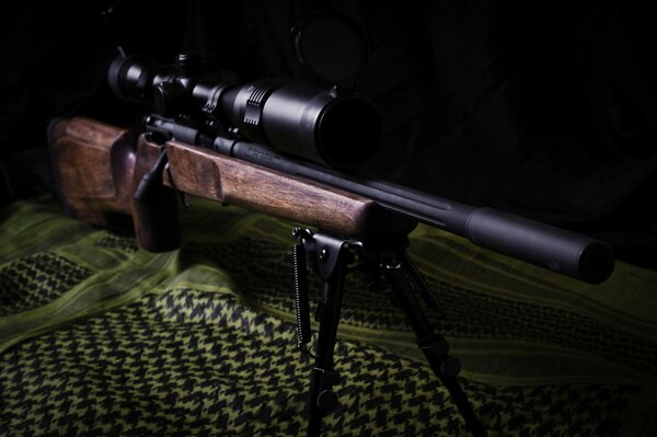 Снайперская винтовка лежащая на ткани