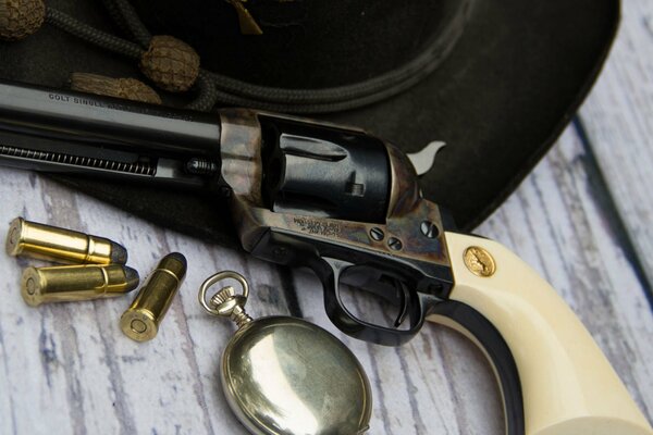 Nature morte d un revolver et des cartouches sur une table avec un chapeau