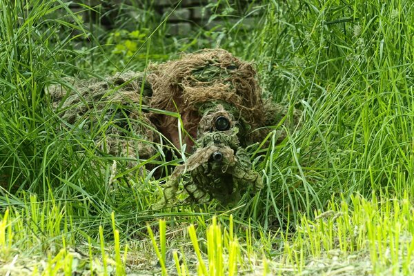 Sniper déguisé avec un fusil, visant de l herbe