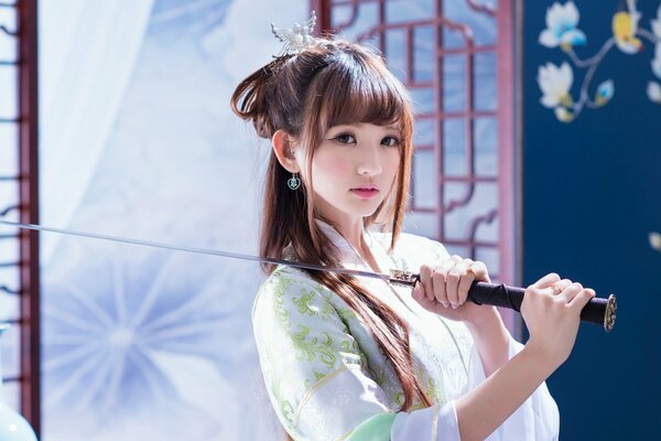 Asian girl in a white dress with a sword on her shoulder
