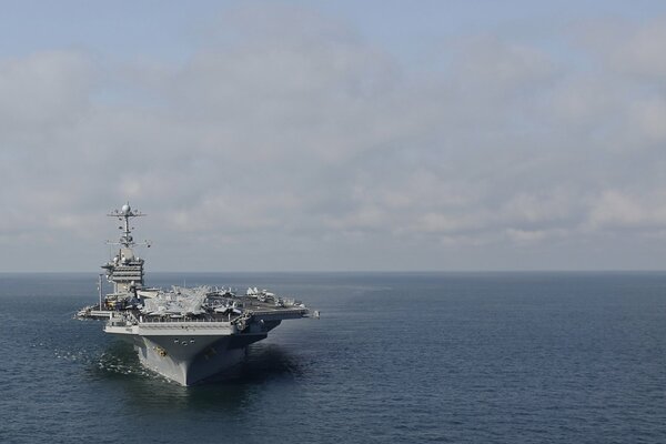 An aircraft carrier ship in action in the middle of the ocean